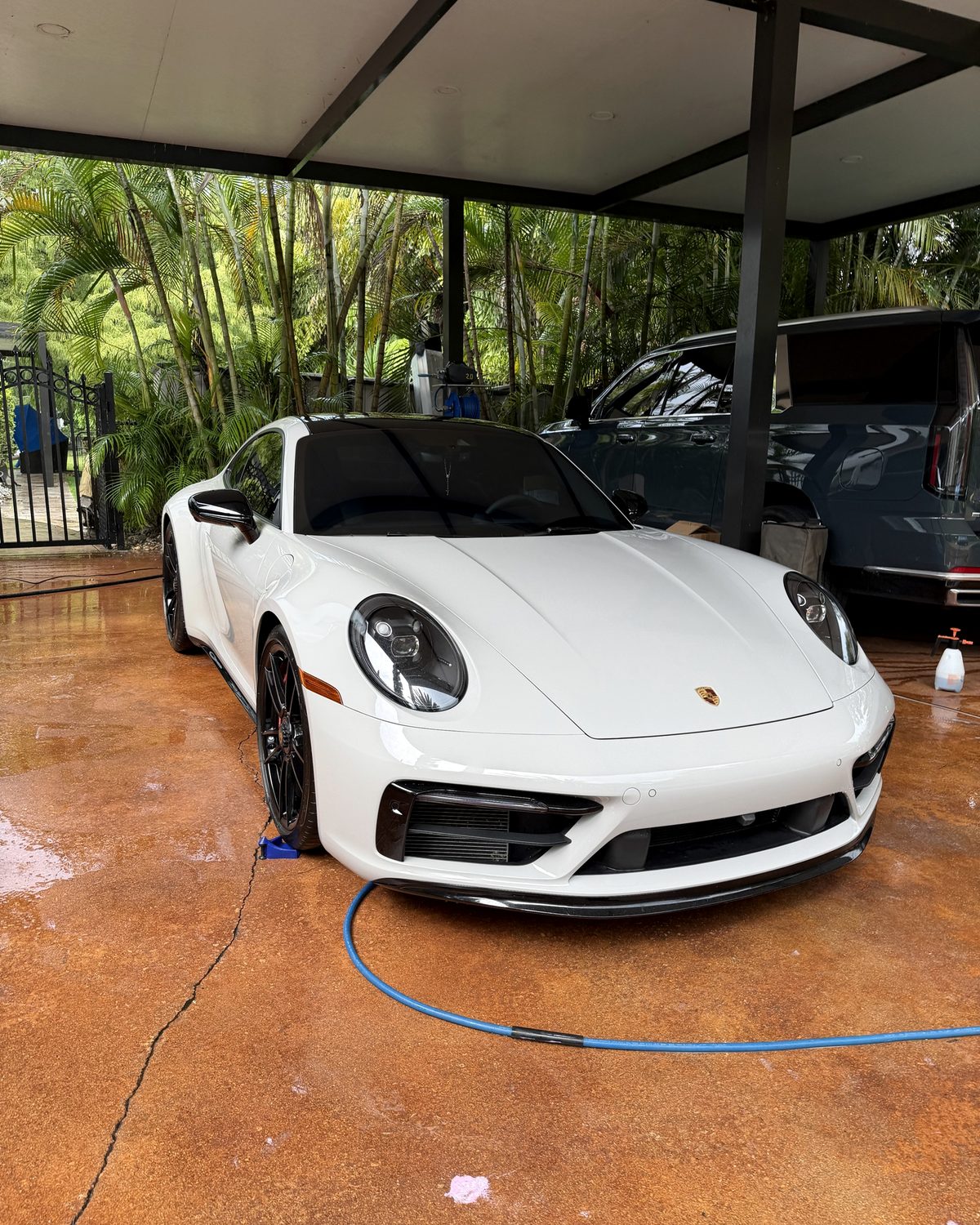 White Porsche 911 GTS detailed under a carport in Broward