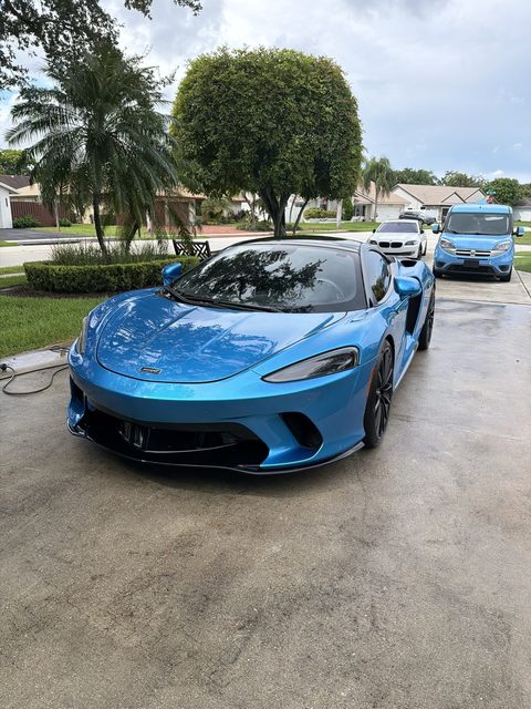 Blue McLaren GT freshly detailed in a Broward driveway
