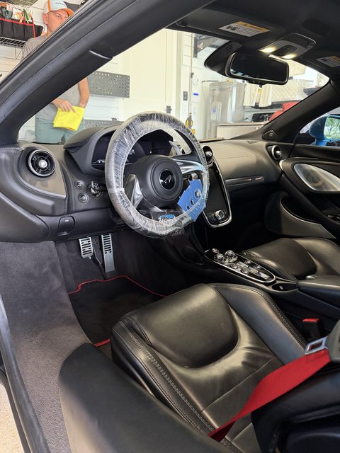 McLaren GT interior after detailing, steering wheel covered during service