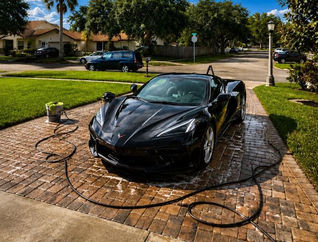 Black Corvette being washed in a Broward driveway